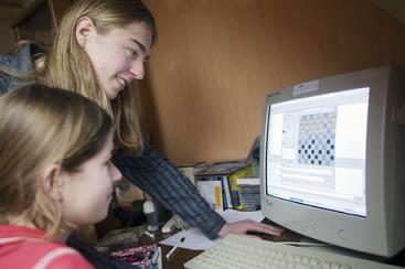 Sander Spaans maakt zijn zus Jorien wegwijs 
in de geheimen van dammen op internet.(Foto William Moore)